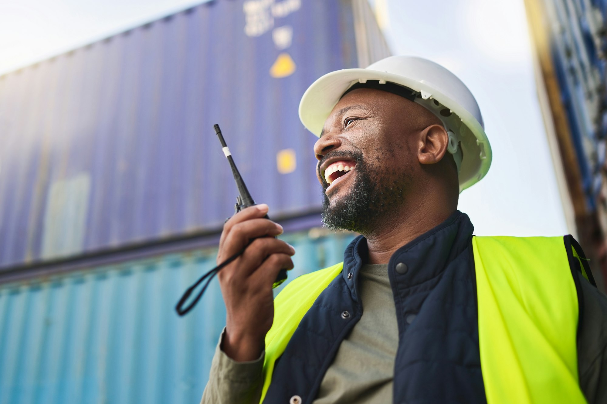 Logistics, supply chain and radio with a man delivery worker talking on a walkie talkie while worki