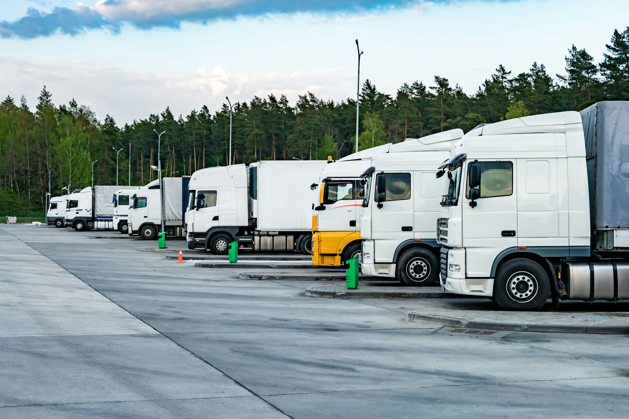 Trucks in a row with containers in the parking lot near forest , Logistic and Transport concept